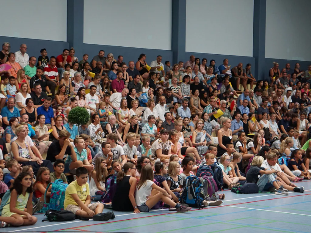 Blick über die sitzenden Kinder in der Halle.